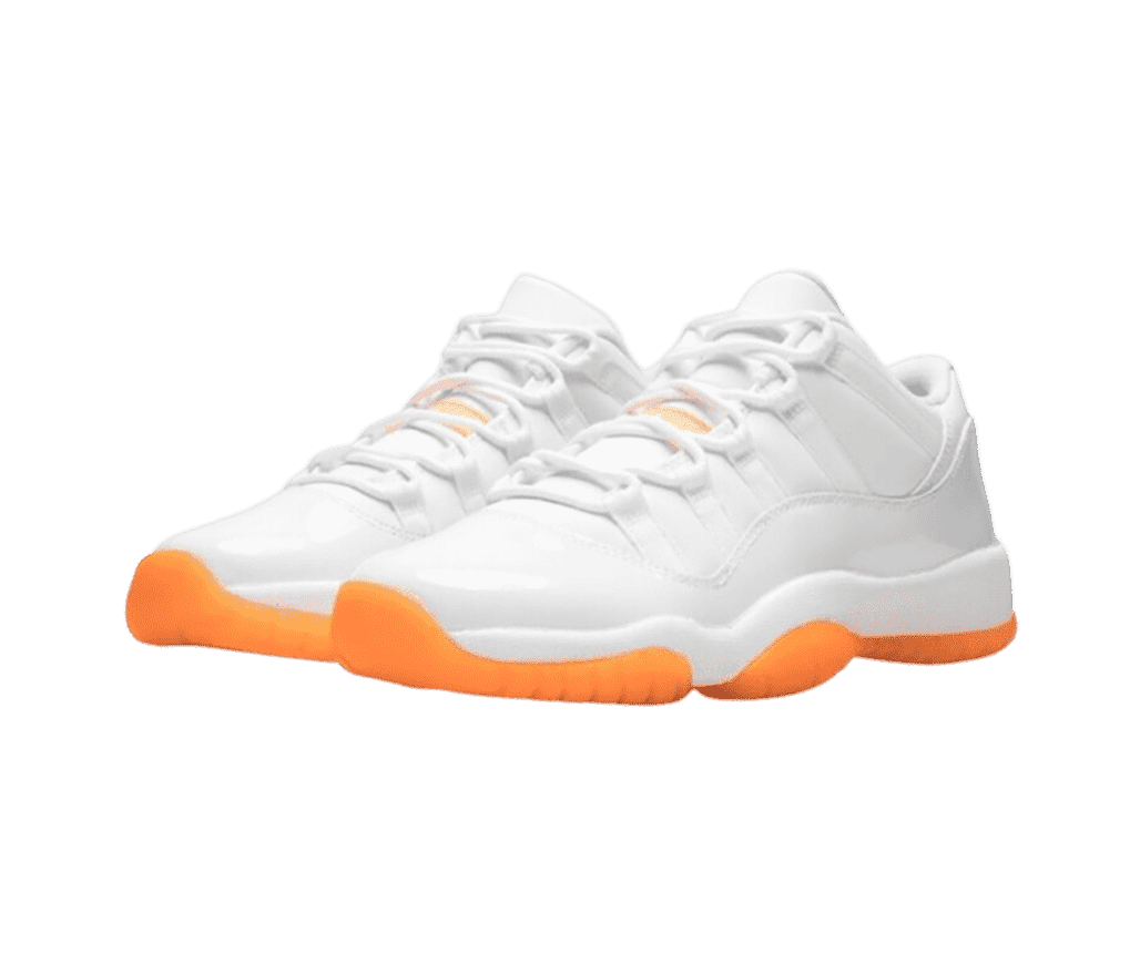 A white pair of AJ11 Low sneakers with patent leather overlays and bright orange outsoles.