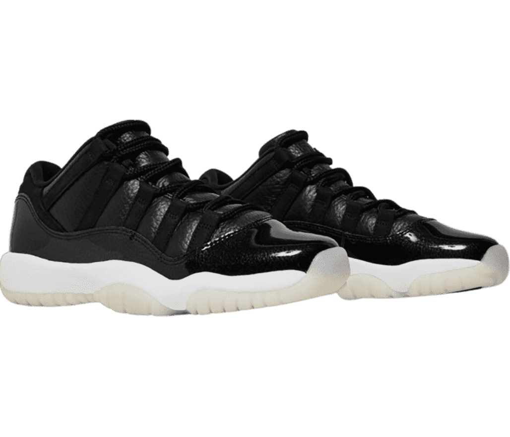 A black pair of AJ11 sneakers with patent leather overlays, white midsoles, and off-white semi-translucent outsoles.