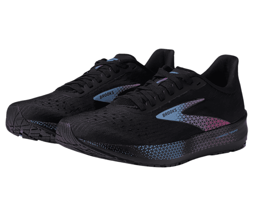A pair of black Spotlight shoes by Brooks have a faded blue and purple pattern along the side of the shoe sole.