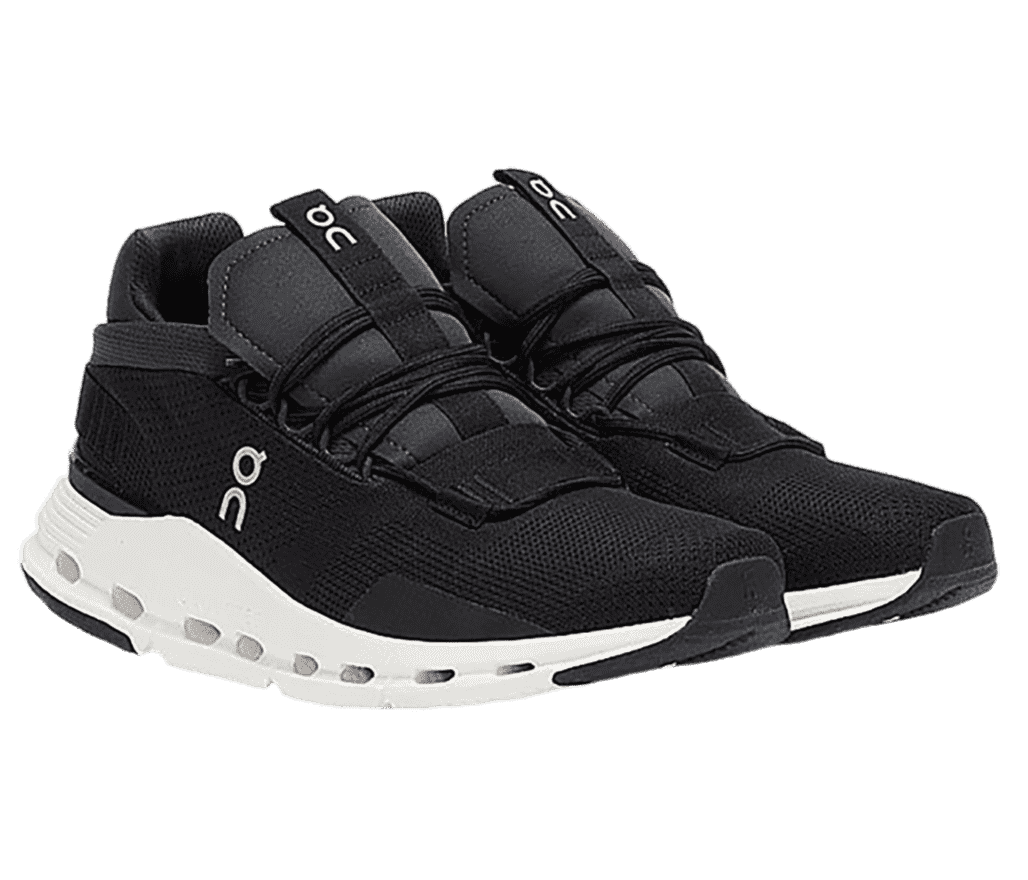 A pair of On Cloudnova sneakers in black with a white soles, strap overlays at the heels, CloudTec midsoles, and loops on the tongue pieces. The On logo runs down the middle of the lateral sides and also on the tongue loops.