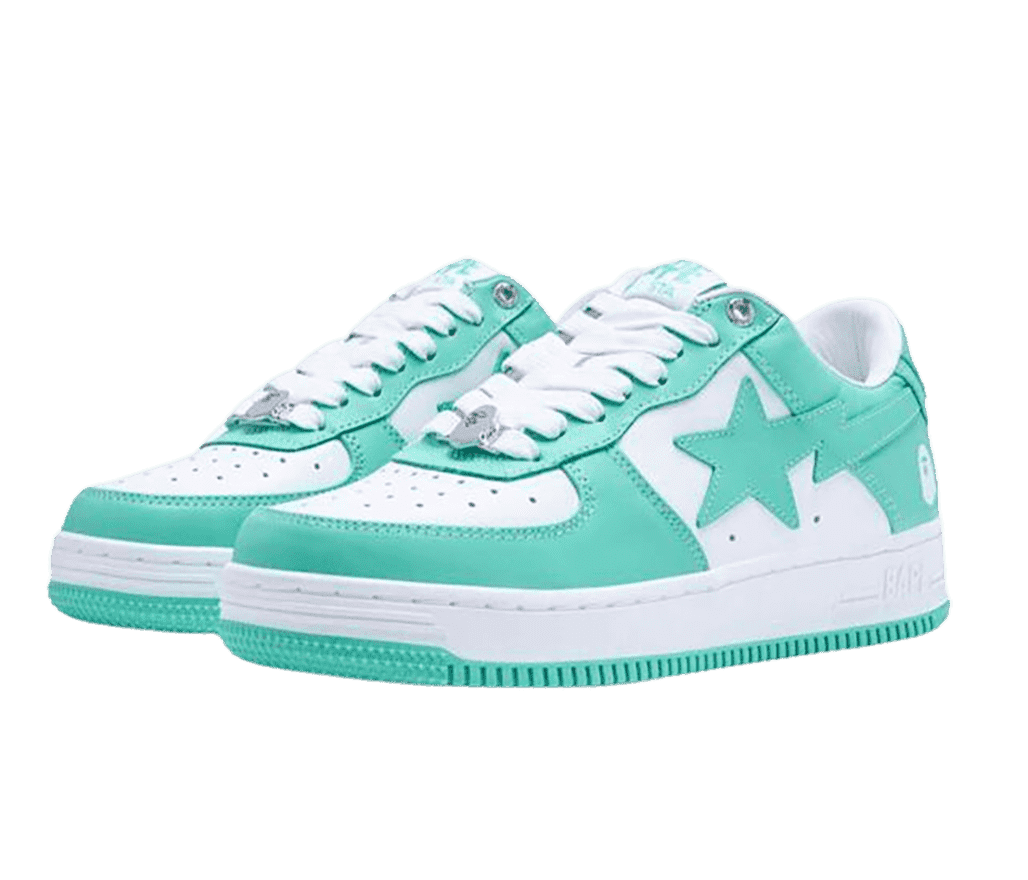 A pair of BAPE STA sneakers in teal and white, a chrome BAPE logo pendant at the bottom of the laces, white BAPE logos at the lateral heels and star-shaped overlays in the midsection.