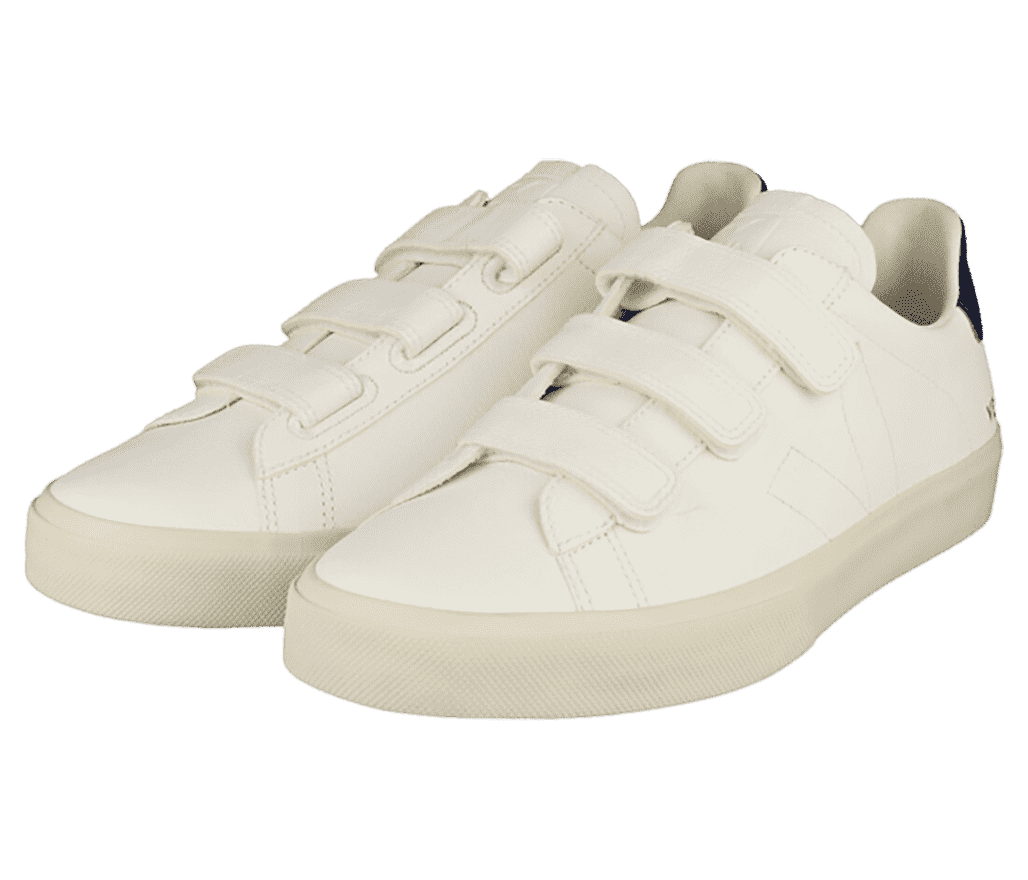 A pair of white VEJA Recife sneakers with a black overlay at the top of the heel, stitching details—including the letter “V” on the lateral side—and velcro straps.