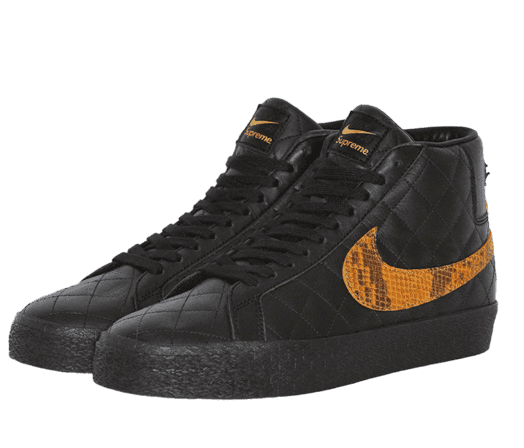 A pair of all-black Supreme Nike sneakers. The Nike logo on the side is gold with a snake-skin pattern. The tongue of the shoe features both the Nike and Supreme logos in gold.