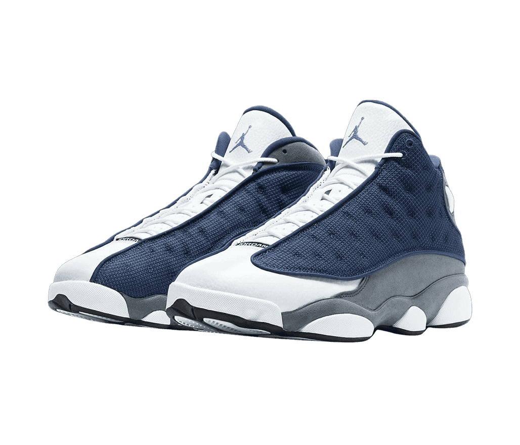 A pair of AJ13 Retro sneakers with gray quarters, white tongue and toeboxes, navy vamps with circular embroidery, and a light blue Jordan logo.