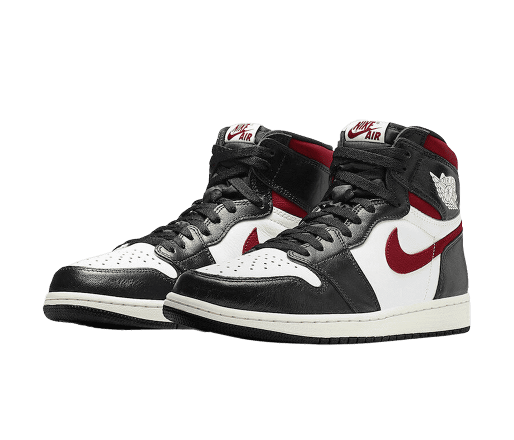 A pair of AJ1 High sneakers in black leather tips, heels, and vamps, white toeboxes and quarters, off-white midsoles, and red suede Nike Swoosh marks and collars.