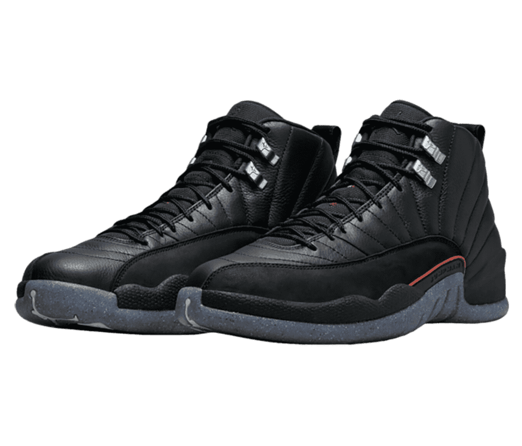 An all-black leather pair of AJ12 Retro sneakers with suede mudguards, speckled navy soles, a red accent on the lateral side, and gray lace locks.