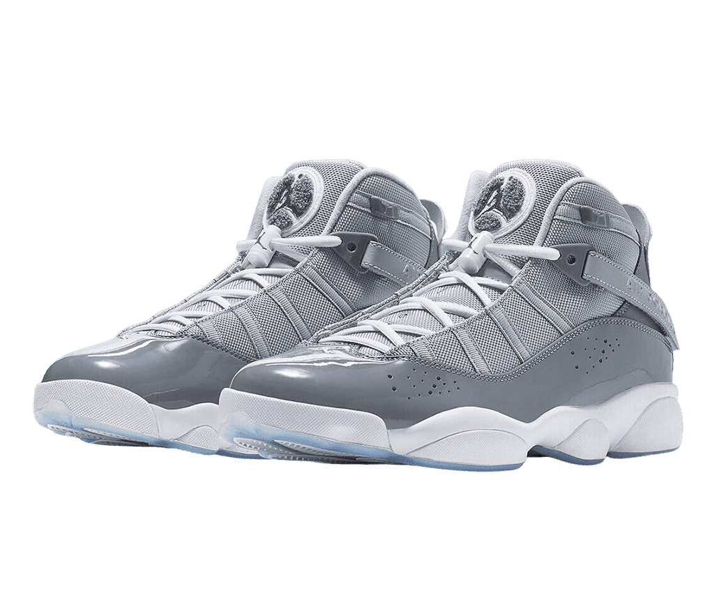 A pair of AJ11 “Cool Gray” sneakers in two shades of gray uppers, white laces and midsoles, gray terrycloth logo patches on the tongues, and light blue translucent outsoles.
