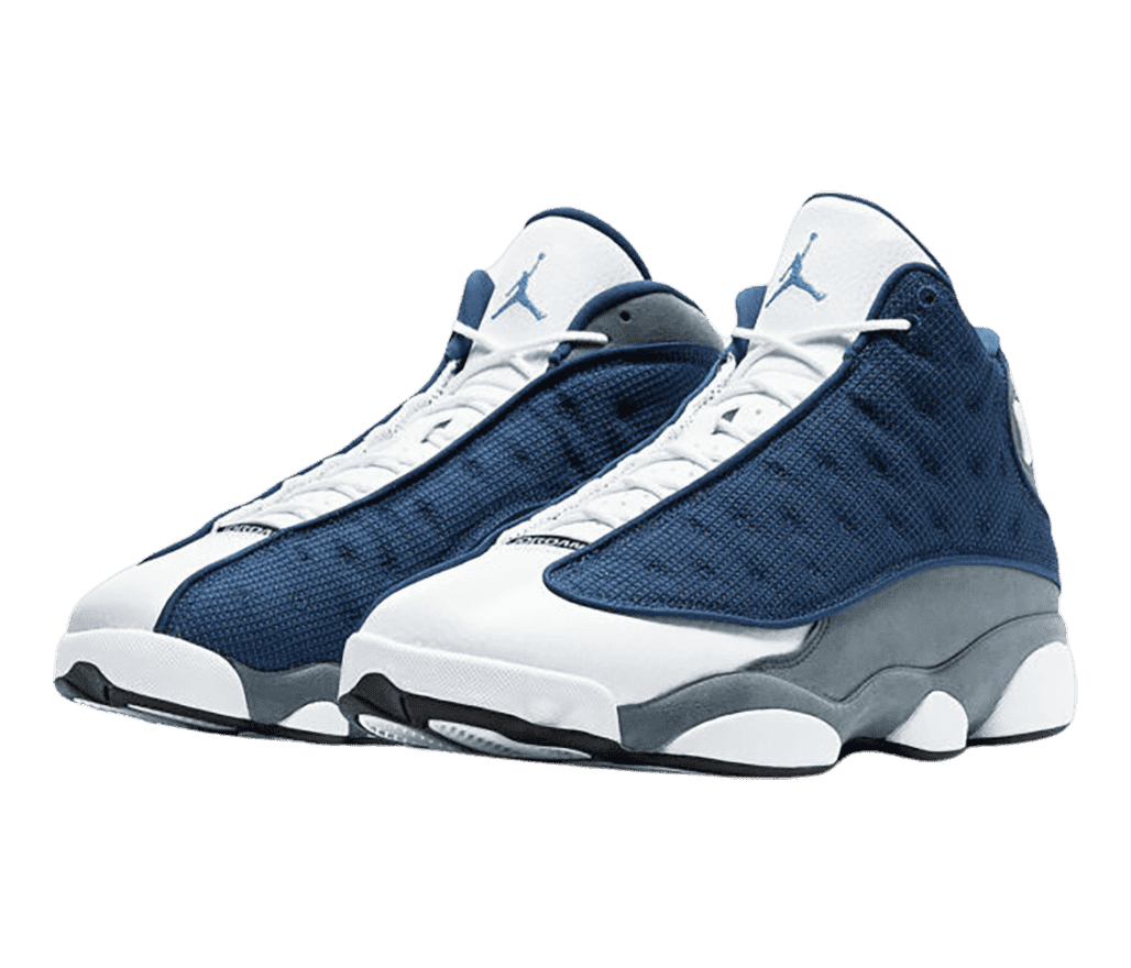 A pair of AJ13 Retro sneakers with gray quarters, white tongue and toeboxes, navy vamps with circular embroidery, and a light blue Jordan logo. 