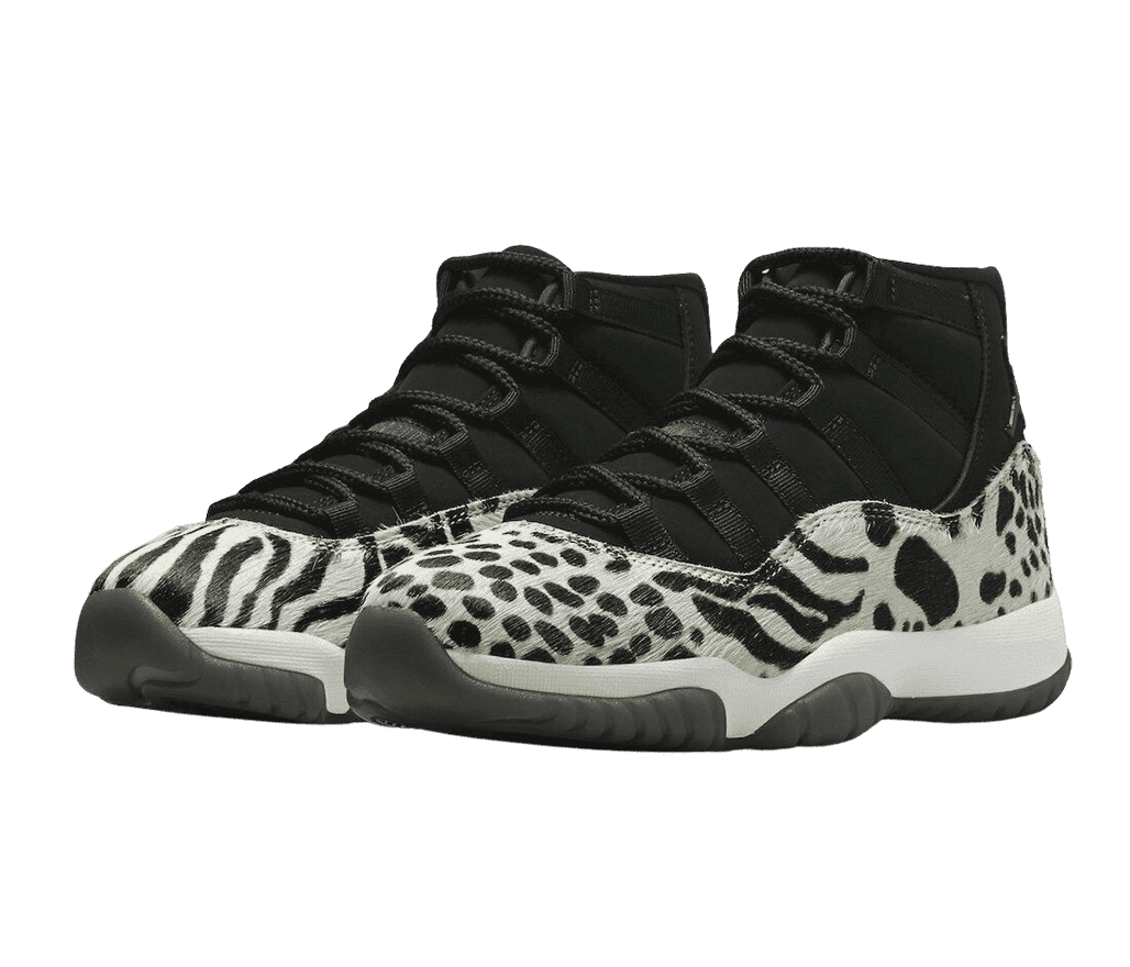 A pair of AJ11 “Animal Instinct” sneakers with black suede uppers, white midsoles, dark gray outsoles, and zebra print pony hair overlays.