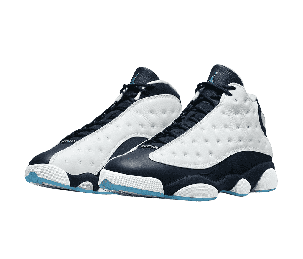A pair of AJ13 “Obsidian” sneakers with dark navy uppers, light blue outsoles, and white vamps with polka-dotted embroidery.