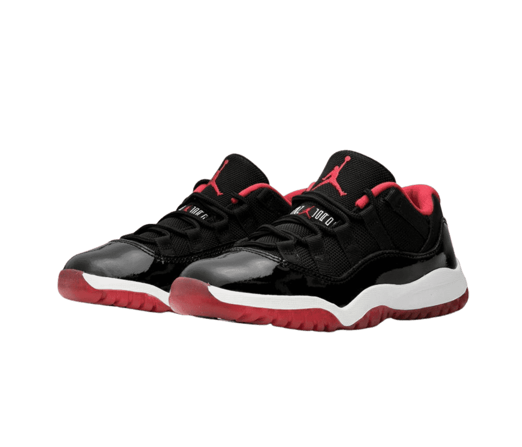 A black pair of AJ11 “Bred” Low sneakers in patent leather upper an fabric. The shoes have white midsoles and red outsoles and logos on the tongue.