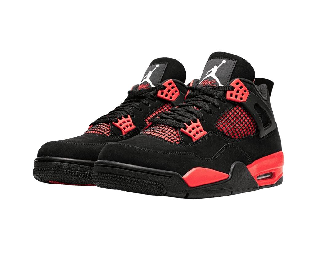A black pair of AJ4 Retro sneakers in suede, black netted sections on top of red on the sides and lower tongue, red lace cages and midoles, and black outsoles.