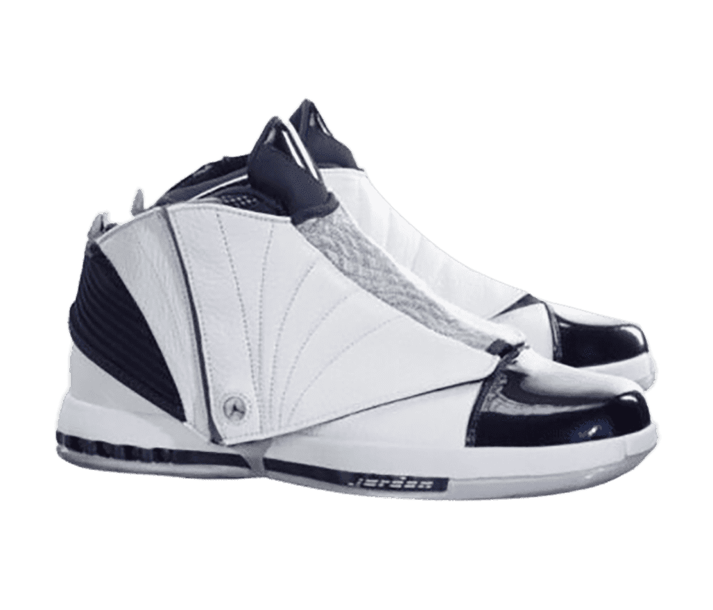 A white pair of AJ16 sneakers with a gray medial section, patent leather toeboxes, lace covers, and dark navy detailing.
