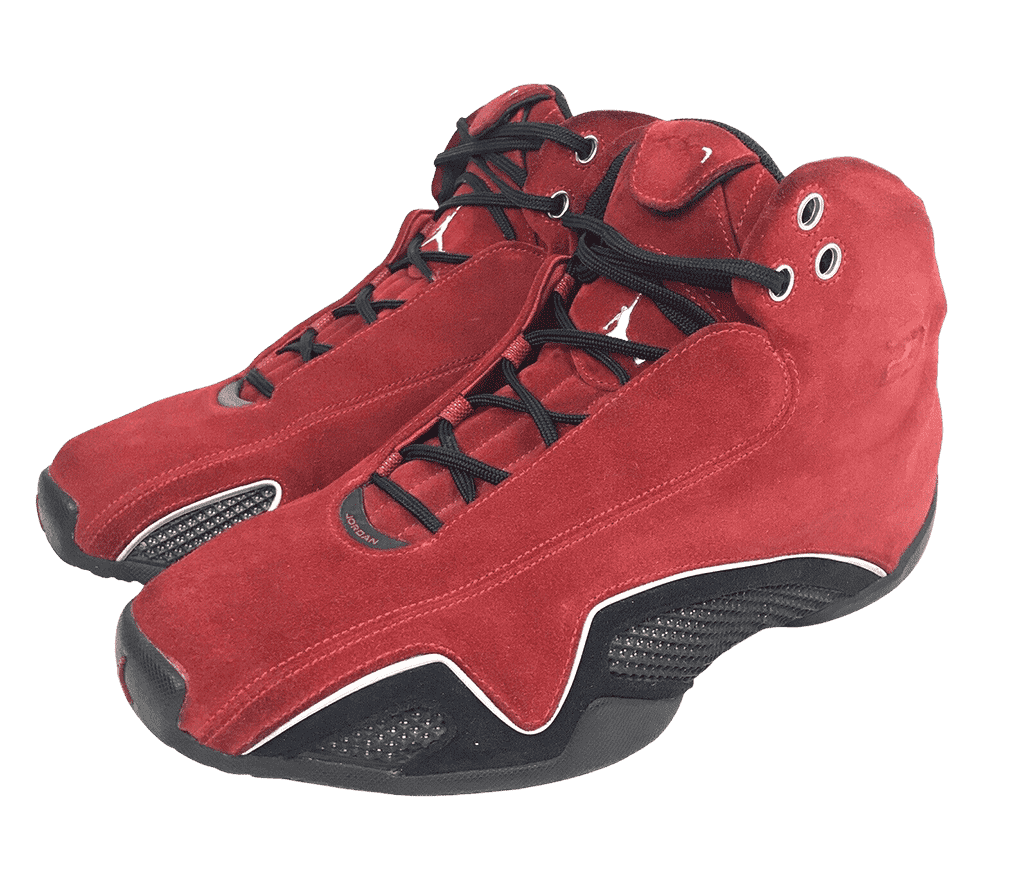 A pair of AJ21 sneakers in red suede uppers with black leather mudguards and metallic line in between.