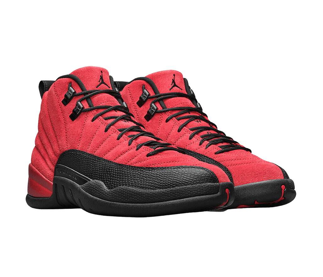 A pair of AJ12 “Reverse Flu Game” sneakers in a red suede, black rubber soles and mudguards, and shiny black lace locks.