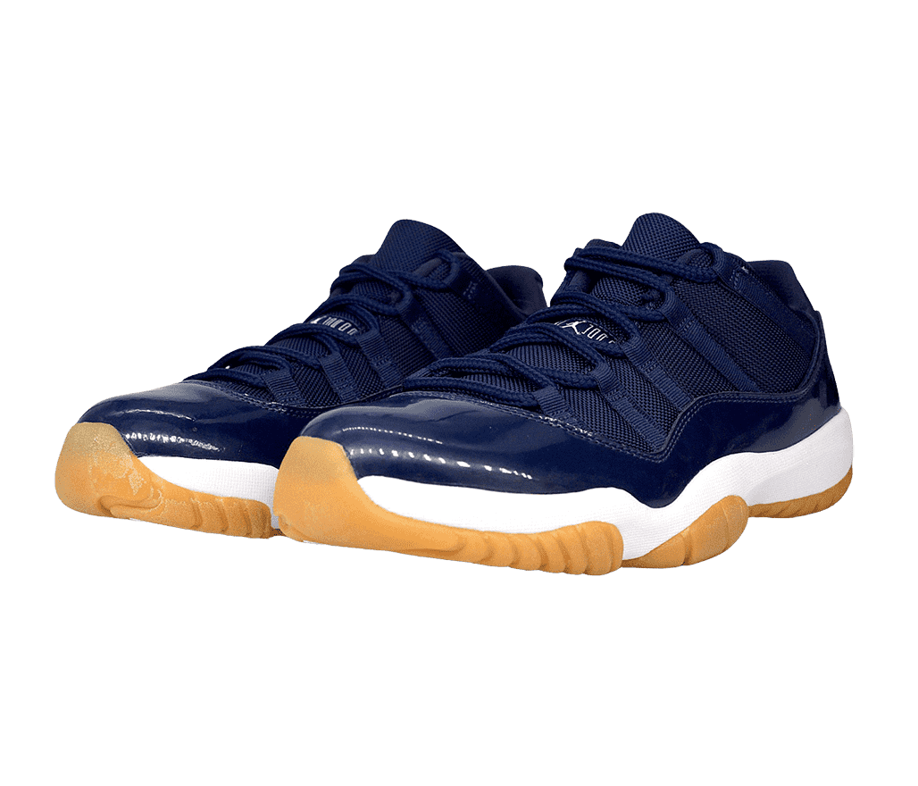 A pair of navy AJ11 Low sneakers in leather and canvas with white midsoles and yellow gum outsoles.