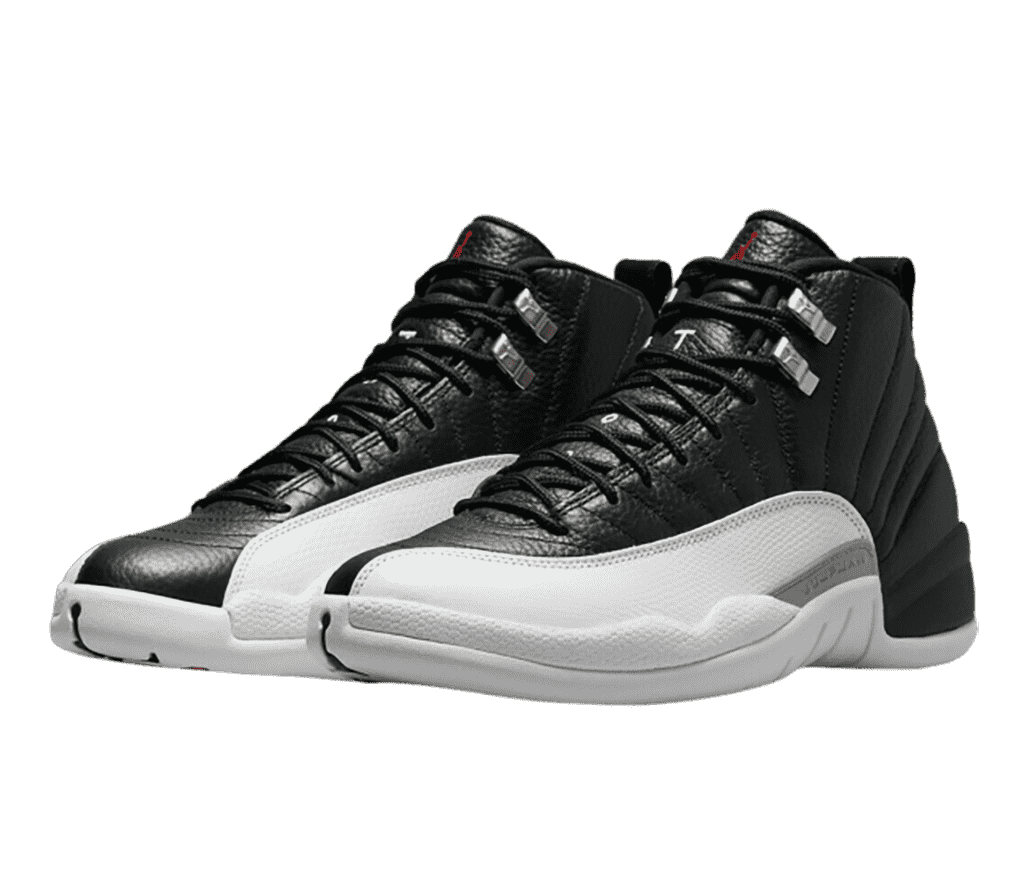 A pair of AJ12 “Playoff” Retro sneakers in black leather, off-white soles, a white leather mudguards, and chrome lace locks.