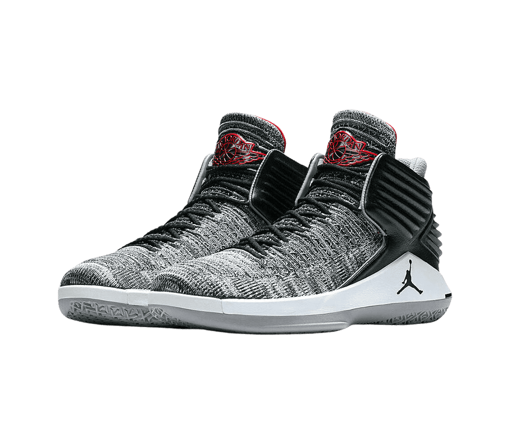 A silver pair of AJ32 “Black Cement” sneakers in a gray Flyknit upper with red accents on the lining and wings logo on the tongue.