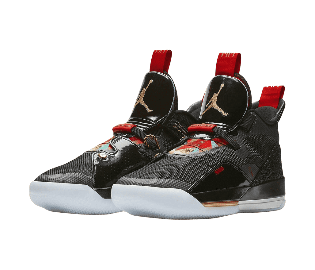 A black pair of AJ33 “Chinese New Year” sneakers in textile mesh, synthetics, and leather. The shoes contain red and gold details, including multicolored patterned designs resembling Chinese patchwork.