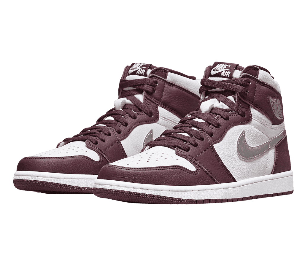 A pair of AJ1 High “Bordeaux” sneakers in white uppers, dark maroon overlays, and metallic silver logos and Swooshes.