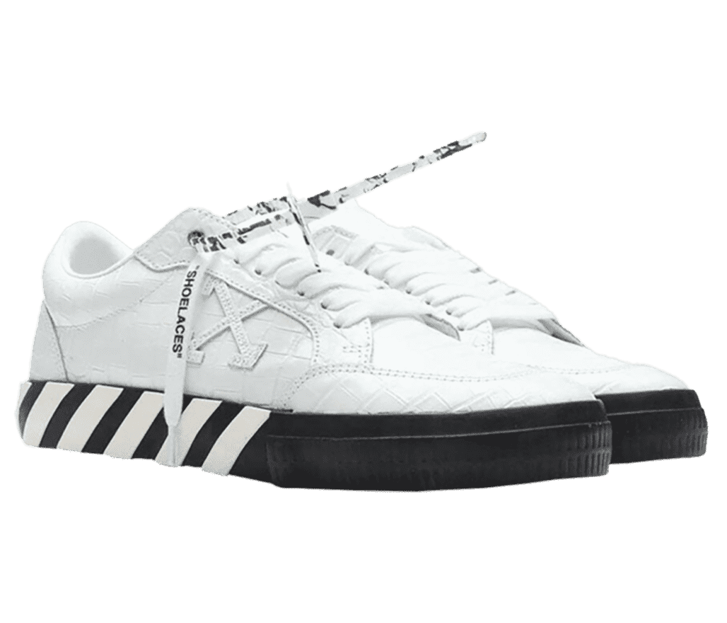 A white pair of Off White Low Vulcanized sneakers with woven-textured uppers and black soles with white diagonal overlays.