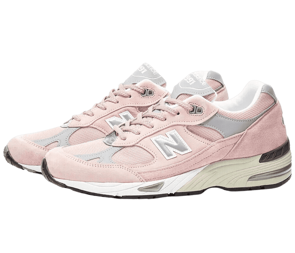 A pair of New Balance 991 sneakers in a soft pastel pink suede and subtle gray overlays.