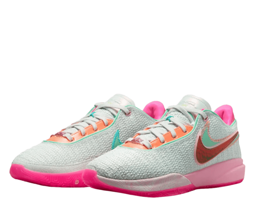 A pair of multi-color Nike running shoes. The shoes are white with soles that are three different shades of pink. The Nike logo is red, with a green accent above it. The shoelaces are white with an orange eyelet.