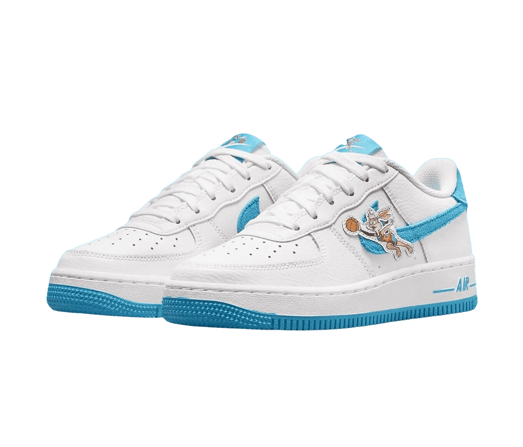 A white leather pair of Space Jam x Nike AF1 Low “Toon Squad” sneakers with a light blue suede Nike Swoosh, outsoles, and Lola Bunny leaping with a basketball in her hand.