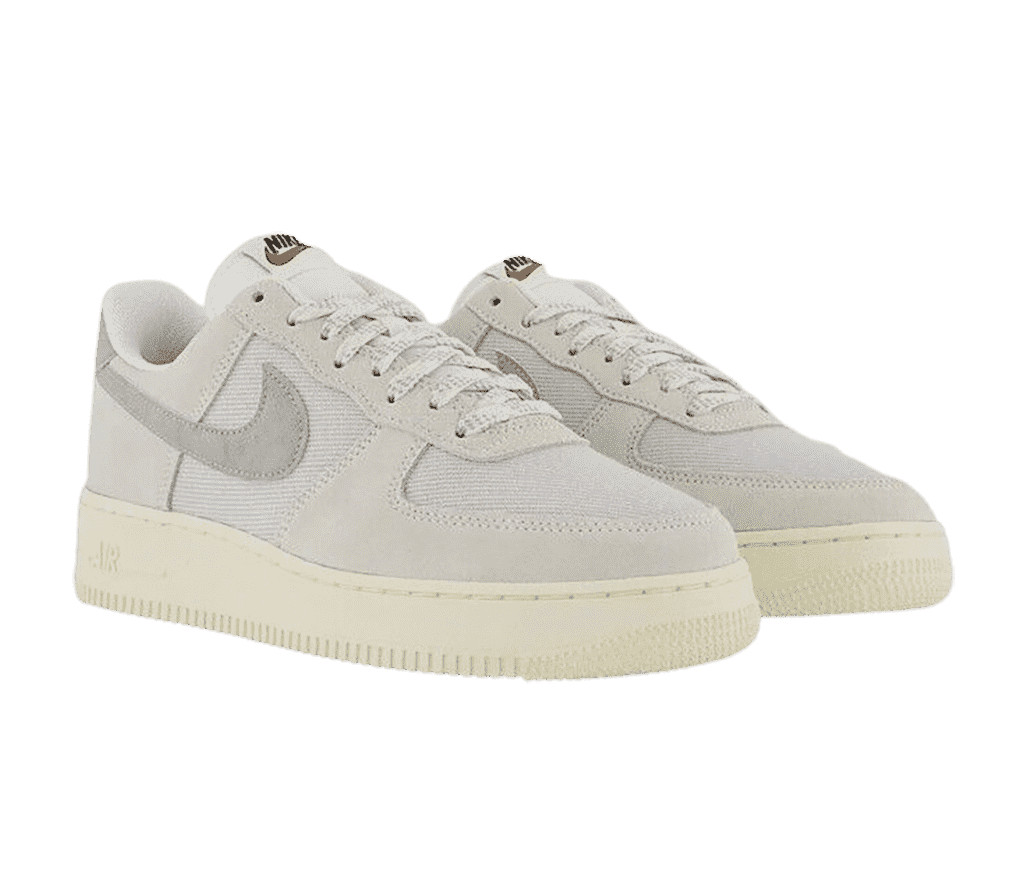 A pair of AF1 Low “Photon Dust Sail” sneakers in light beige canvas and suede and a gray felt Nike Swoosh.