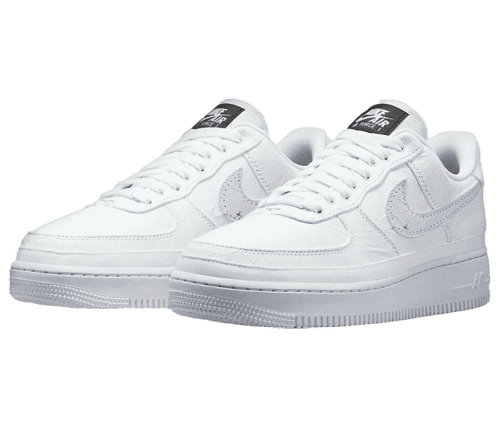 A pair of AF1 Low Tear-Away sneakers in all-white with a black logo tag on the tongue.