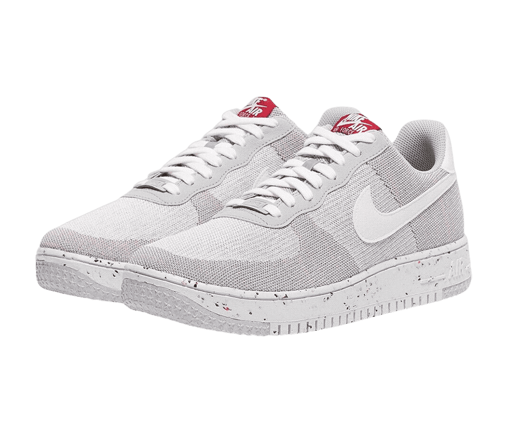 A pair of AF1 Crater FlyKnit “Wolf Grey” sneakers in gray and washed-out pink and rubber soles speckled with blue and red.