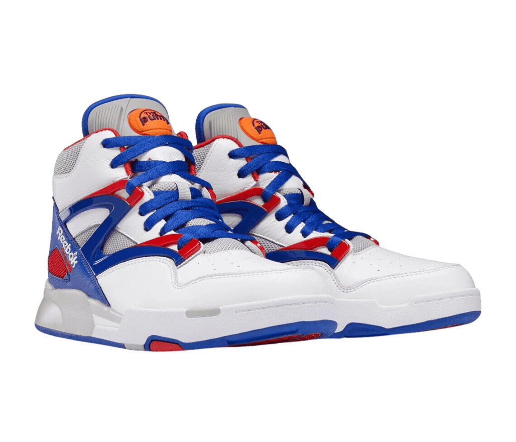 A white pair of Reebok Pump Omni Zone 2 sneakers with blue and red detailing and an orange protruding basketball on the tongue pull.