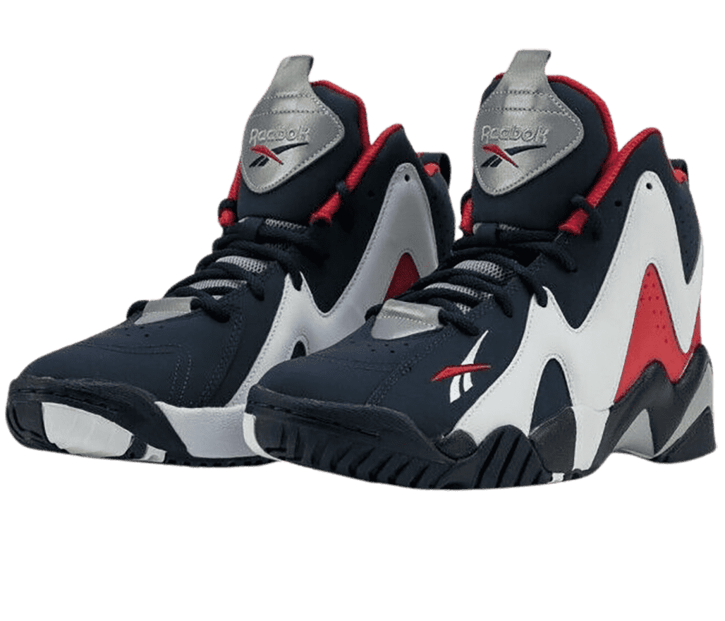 A pair of Reebook Kamikaze sneakers in dark navy, gray, and red suede with large wavy overlays and the logo in red and white on the outer toe.