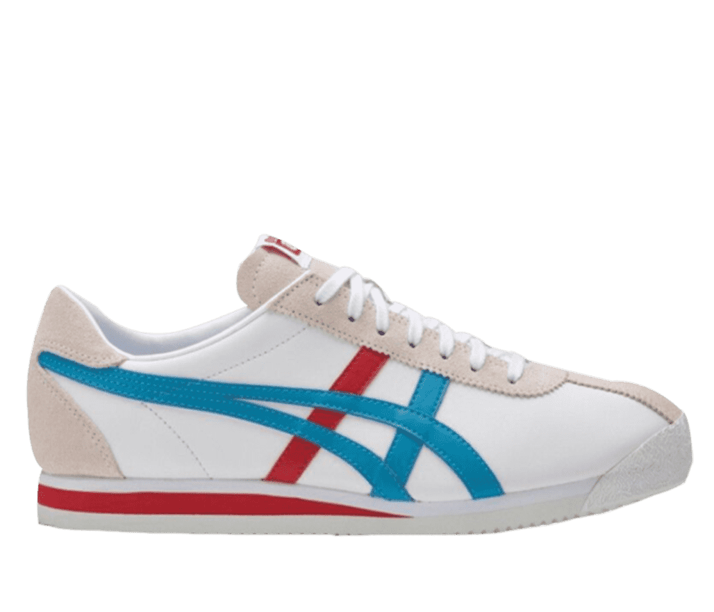A side shot of a white Onitsuka Tiger shoe. It has a cream-colored upper and heel, with a red accent on its white soles. The side of the shoe features a red and blue design.