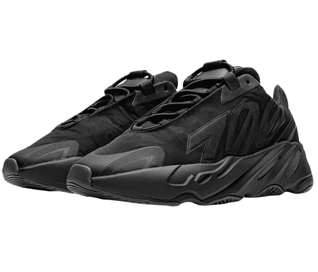 A pair of Yeezy Boost 700 “Triple Black” sneakers in suede, rubber, and leather. The shoes have toeguards, wide soles, elastic loop laces, and the number “700” overlayed on the lateral sides.